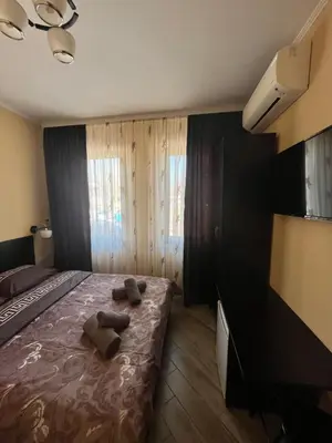 a bedroom with a bed with two brown towels on it at Guesthouse Zornitsa in Hisarya