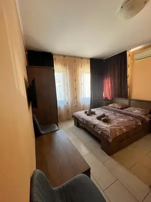 a bedroom with a bed and a table and a chair at Guesthouse Zornitsa in Hisarya