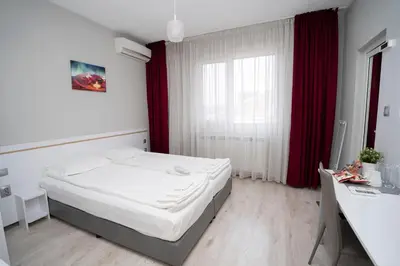 a small bedroom with a bed and a window at Guest house Traikovi in Petrich