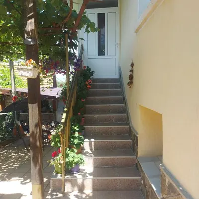 a stairway leading up to a white door with flowers at Viktoria House in Sapareva Banya
