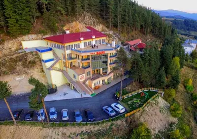 a large building with cars parked in a parking lot at Safi in Dospat