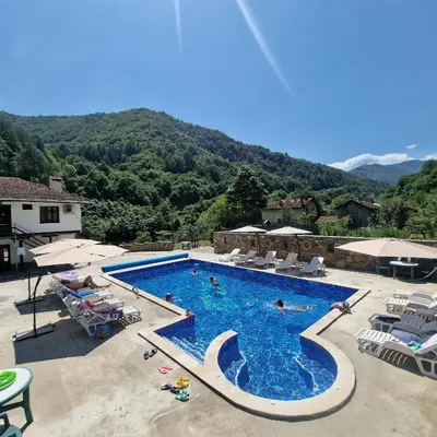 a large swimming pool with chairs and people in it at Guest House Ivan in Cherni Osŭm