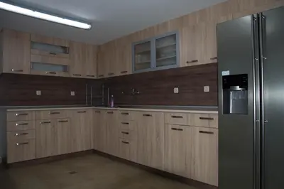a kitchen with wooden cabinets and a stainless steel refrigerator at Guest House Ivan in Cherni Osŭm