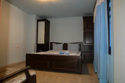 a bedroom with a bed and a mirror at Guest House Ivan in Cherni Osŭm