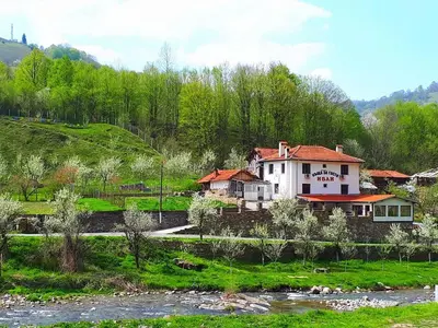 a house on a hill next to a river at Guest House Ivan in Cherni Osŭm