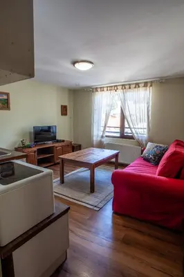 a living room with a red couch and a table at Kutsinska House in Progled