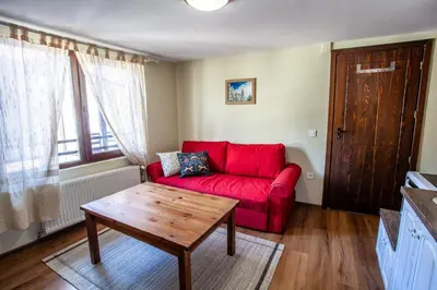 a red couch in a living room with a table at Kutsinska House in Progled