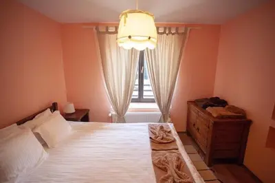 a bedroom with a large bed and a window at Kutsinska House in Progled