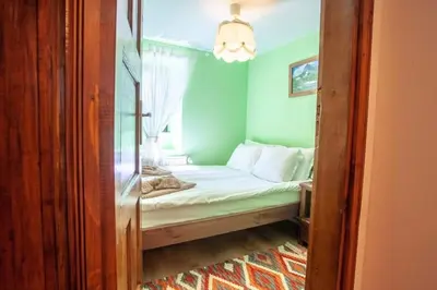 a small bedroom with a bed with a window at Kutsinska House in Progled