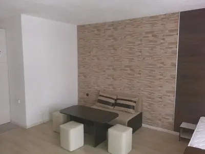 a room with a bed and a black table and stool at Apartments Hristovi in Sandanski