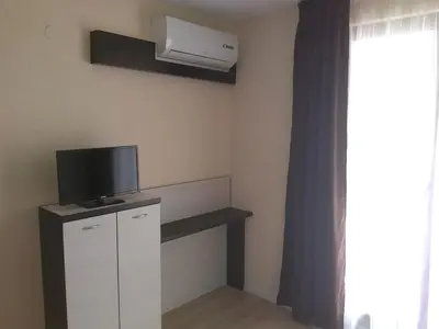 a living room with a tv and a window at Apartments Hristovi in Sandanski
