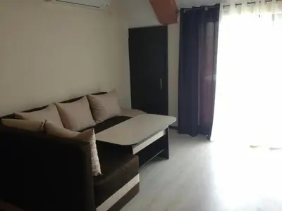 a living room with a couch and a window at Apartments Hristovi in Sandanski