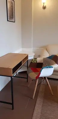 a living room with a table and a chair at Presidency House Self Check-in Apartments in Sofia