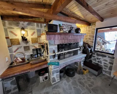 a kitchen with a stone fireplace in a room at Villa O Sole Mio in Progled