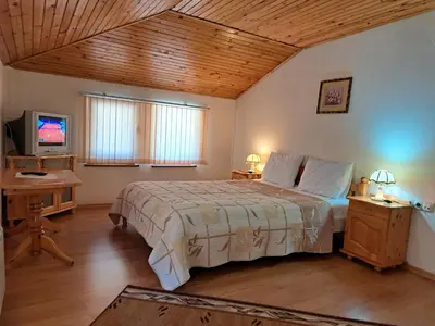 a bedroom with a large bed and a tv at Guest House Benita in Devin