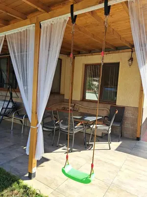 a swing on a patio with a table and chairs at Guest House Benita in Devin