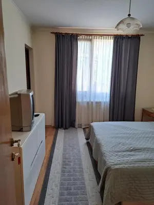 a bedroom with a bed and a tv and a window at Guest House Benita in Devin