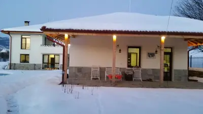 a house with snow on the ground in front of it at Mountain View Vacation Home in Balabanska