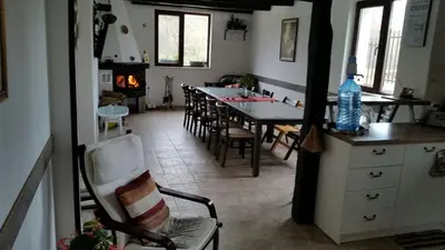 a kitchen and dining room with a table and a fireplace at Mountain View Vacation Home in Balabanska