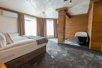 a bedroom with a bed and a large window at V Chalet Residence in Velingrad