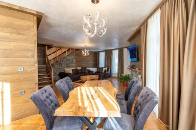 a dining room with a wooden table and chairs at V Chalet Residence in Velingrad
