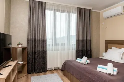 a hotel room with a bed and a large window at Panorama Apartment in Velingrad