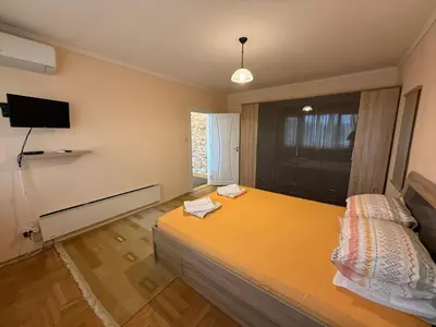 a bedroom with a bed and a tv on the wall at Apartment Durvenitza in Sofia