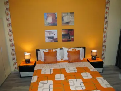 a bedroom with a bed with two lamps on tables at Apartments Vasil Levski in Plovdiv
