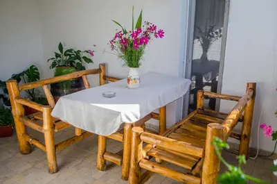 a table and chairs with a vase of flowers on it at Guesthouse Juli in Sapareva Banya