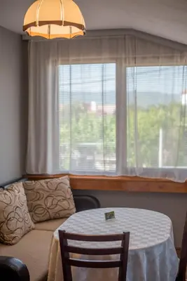a living room with a table and a couch and a window at Guesthouse Juli in Sapareva Banya