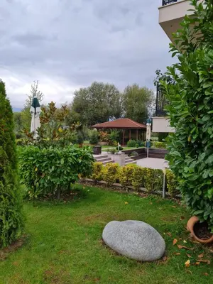 a garden with a rock in the grass at Guesthouse Green Fields in Garmen