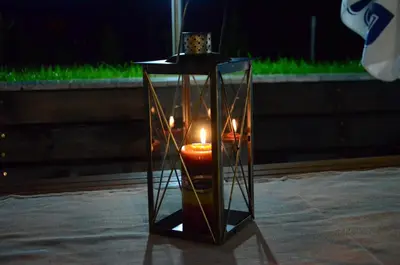 a candle in a glass container with a candleholder at Guesthouse Green Fields in Garmen