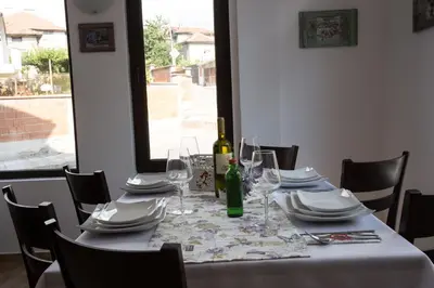 a table with glasses and plates and a bottle of wine at Sveti Nikola Family Hotel Sapareva Banya in Sapareva Banya