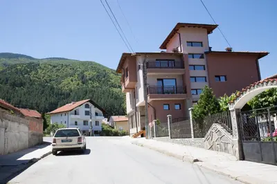 a car driving down a street next to a building at Sveti Nikola Family Hotel Sapareva Banya in Sapareva Banya