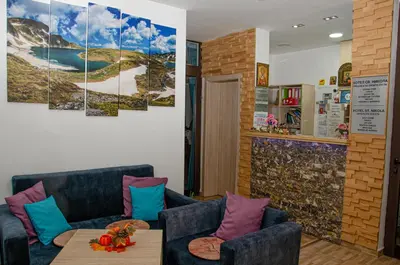 a living room with two blue couches and a table at Sveti Nikola Family Hotel Sapareva Banya in Sapareva Banya