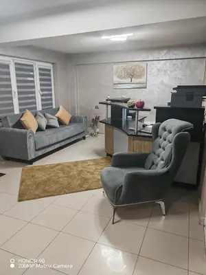 a living room with two couches and a kitchen at Family Hotel Kartala in Blagoevgrad
