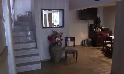 a living room with stairs and a vase of flowers at Family Hotel Kartala in Blagoevgrad