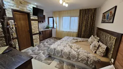 a bedroom with a bed and a stone wall at Villa Hills - къща за гости с храна in Orlino