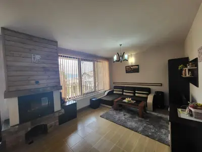 a living room with a couch and a fireplace at Ваканционна къща ,,Родопски уют 