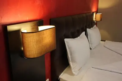 a bedroom with two beds with white pillows and a lamp at Central Guest Rooms in Asenovgrad