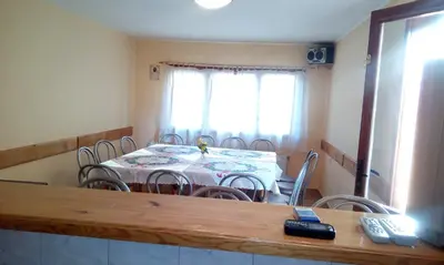 a dining room with a table and chairs and a room with at Guest House Lorian in Madzhare