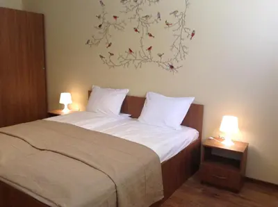 a bedroom with a bed with two lamps and a painting on the wall at Apartment Sredetz in Sofia