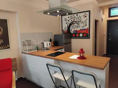 a kitchen with a counter and chairs in a room at Embassy Apartment in Sofia