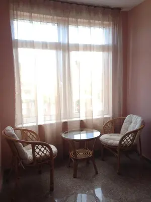 a room with two chairs and a table and two windows at Center Guest House in Sapareva Banya