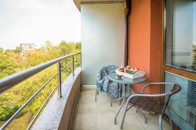 a balcony with a table and chairs and a window at Domus Apartments Old Town with Garage in Plovdiv