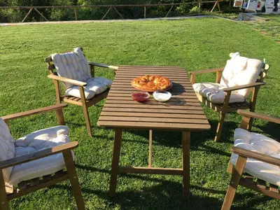 a wooden table with a pizza on it with two chairs at Leshten Guest Homes in Leshten