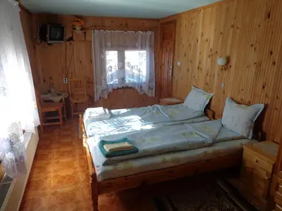 a bedroom with a bed and a table and a window at Family Hotel Ecorelax in Madzhare