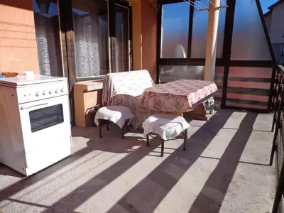 a table and two chairs on a porch with a stove at Family Hotel Ecorelax in Madzhare