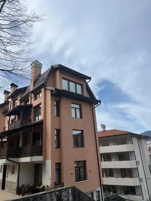 a large brick building next to a apartment building at Panorama Guest House in Smolyan