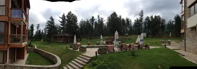 a yard with chairs and a building and trees at Entire Private Apartment in Pirin Golf & Country Club in Bansko